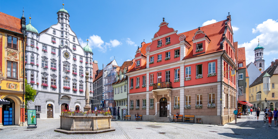 Der Marktplatz von Memmingen mit bunten Gebäuden und einem Brunnen