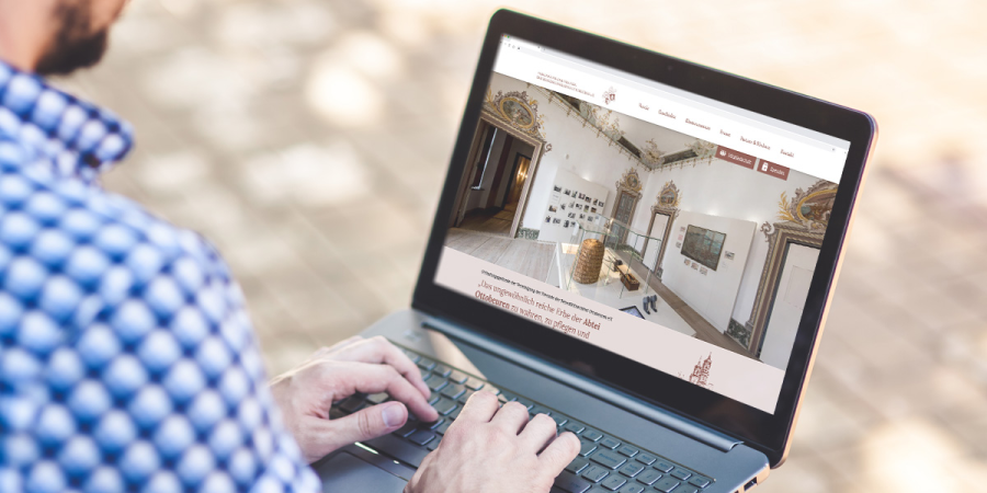 Ein Mann sieht sich auf seinem Laptop die Website der Vereinigung Ottobeuren an