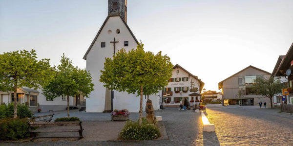 Der Dorfplatz von Oy-Mittelberg während des Sonnenuntergangs in warmen Licht